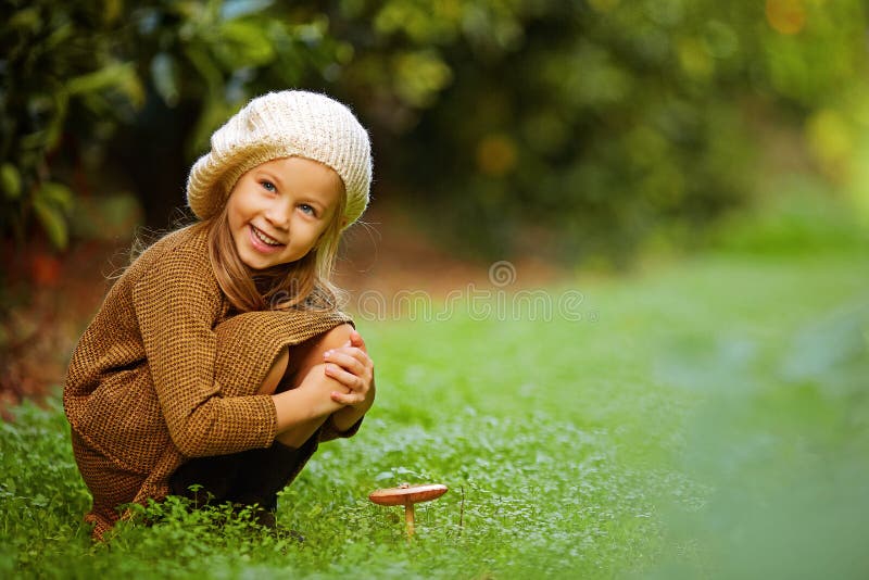 Adorable girl on meadow with mushroom