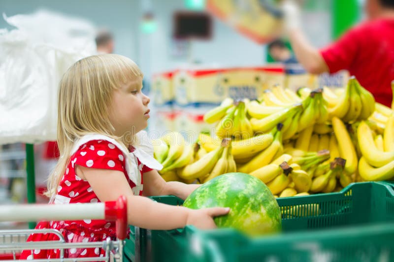 Adorable girl sit on cart holding watermelon