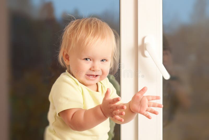 Adorable girl stay on the window sill