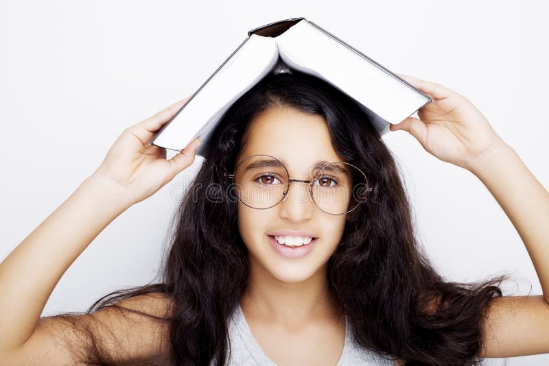 Adorable Girl Studying With Eyeglasses And Book On The Head Stock Image