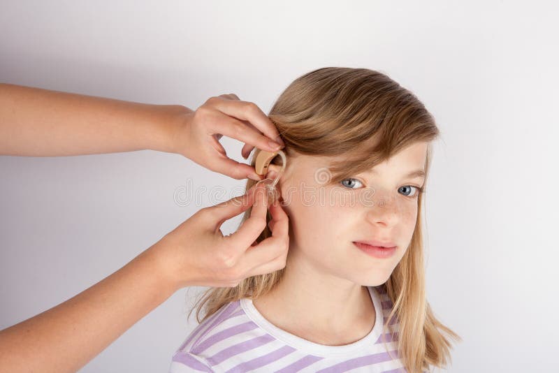 Adorable girl trying a hearing aid