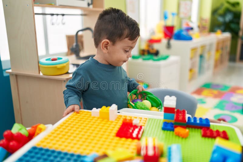Adorable Hispanic Boy Playing with Play Kitchen Standing at