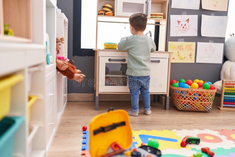 Adorable Hispanic Boy Playing with Play Kitchen Standing at