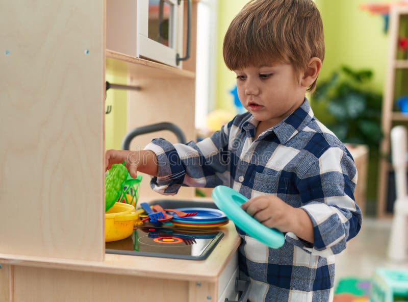 Adorable Hispanic Boy Playing with Play Kitchen Standing at