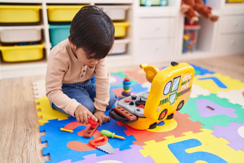 Adorable Hispanic Boy Playing with Technician Tools Toy Sitting on