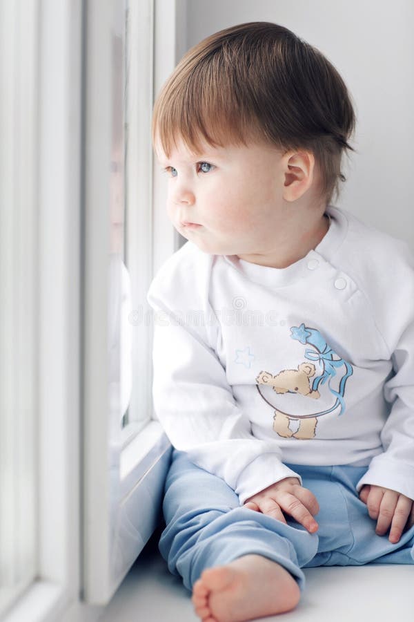 Adorable Little Baby Seating Windowsill Looking Out Window Stock Photos