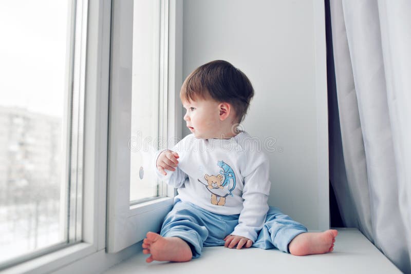 Adorable Little Baby Seating Windowsill Looking Out Window Stock Photos