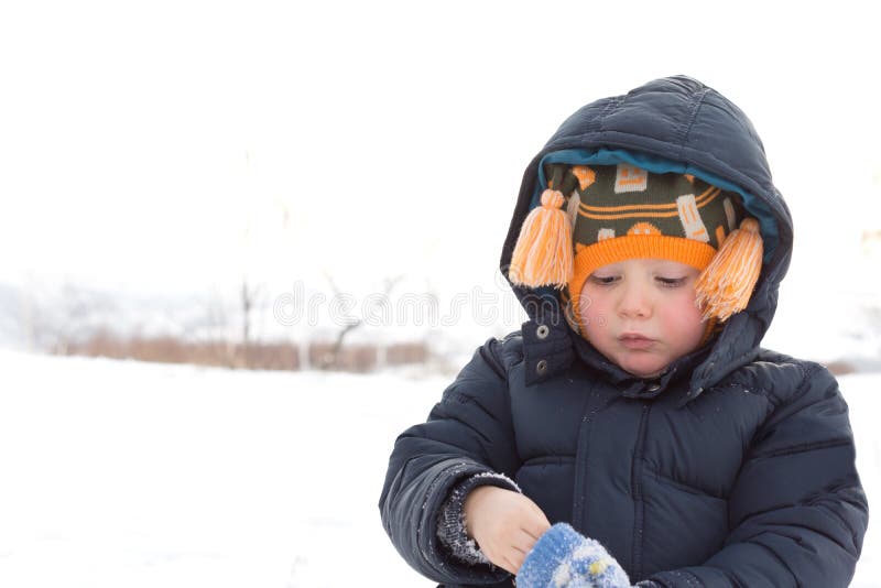 Adorable little boy putting on his mittens