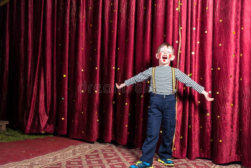 Adorable little boy singing on stage during a play