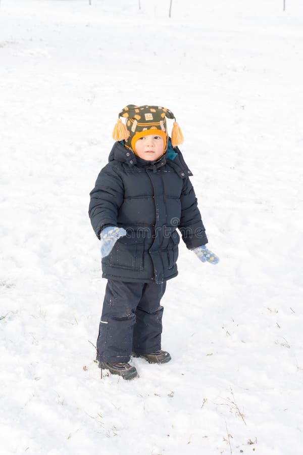 Adorable little boy standing in snow