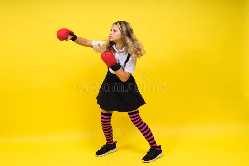 An Adorable Little Girl Boxer Practicing Punches in Studio Stock Photo