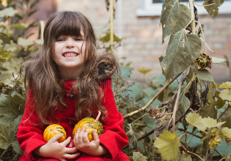 Adorable little girl having fun on a pumpkin patch on beautiful autumn day outdoors stock photos Adorable little girl having fun on a pumpkin patch on beautiful autumn day outdoors stock photos