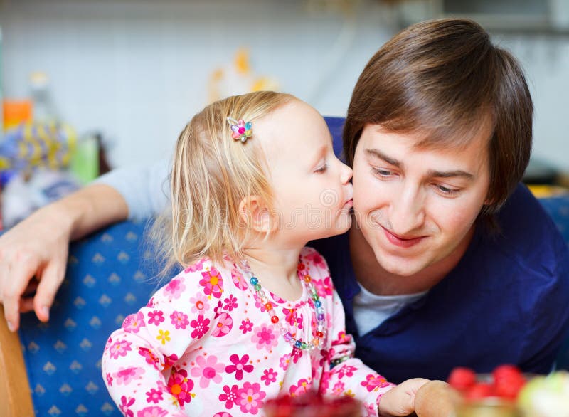 Adorable little girl kissing her father royalty free stock photography.