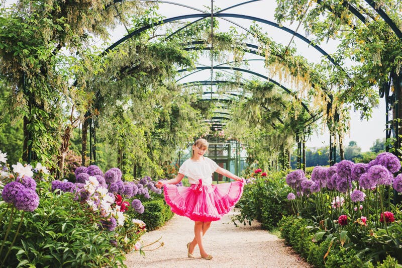 Pretty little girl playing in a beautiful garden