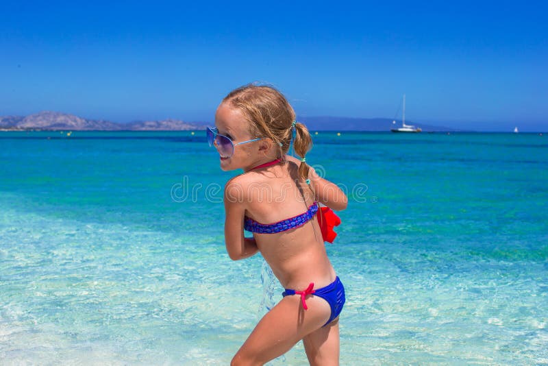 Adorable little girl playing with toy on beach