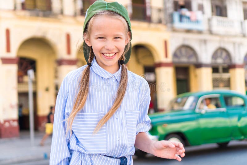 Adorable little girl in popular area in Old Havana, Cuba. Portrait of kid background vintage classic american car royalty free stock photos Adorable little girl in popular area in Old Havana, Cuba. Portrait of kid background vintage classic american car royalty free stock photos