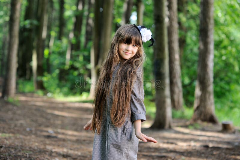 Adorable little girl posing in summer forest