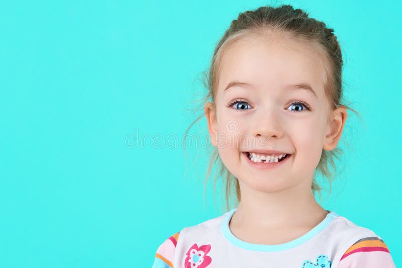Rozkošné dievčatko sa usmieva a predvádza svoj prvý vypadnutý mliečny zub. Roztomilý portrét predškoláka.