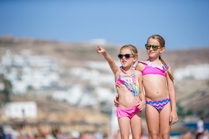 Adorable little girls having fun during beach vacation.