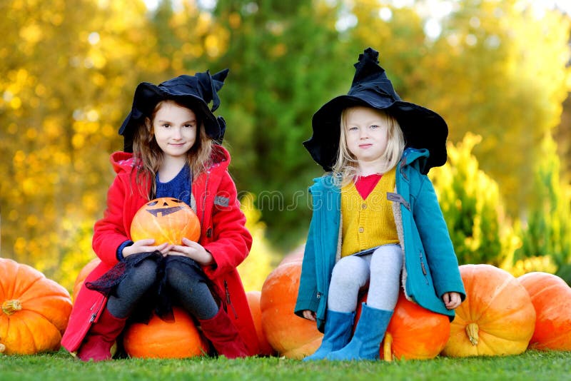 Adorable Little Girls Wearing Halloween Costume Having Fun on a Pumpkin ...