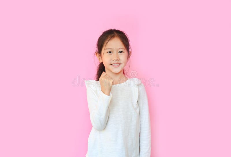 Adorable little kid girl with hand expression fight sign isolated in pink background. Portrait asian child with confident gesture royalty free stock images Adorable little kid girl with hand expression fight sign isolated in pink background. Portrait asian child with confident gesture royalty free stock images