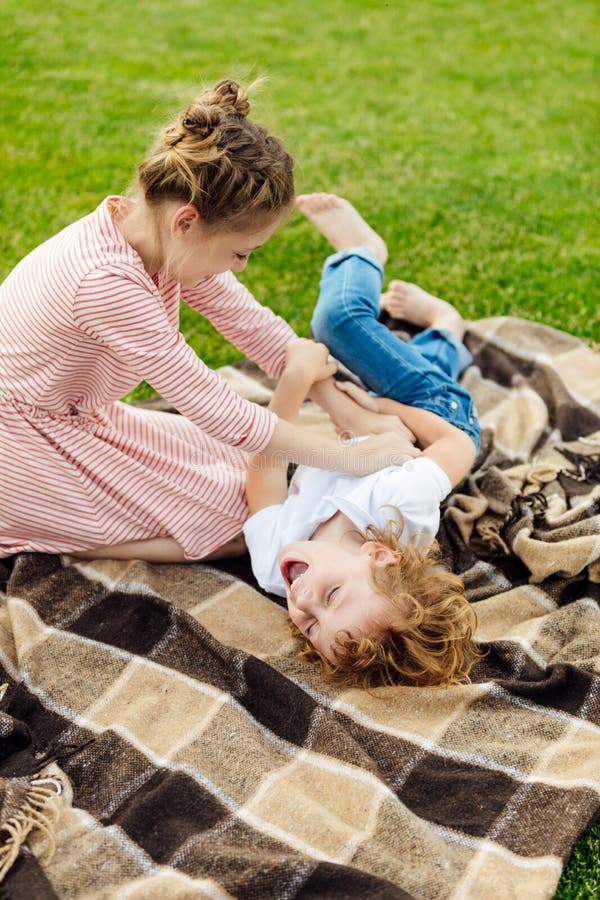 adorable little siblings having fun on plaid on green meadow stock images adorable little siblings having fun on plaid on green meadow stock images