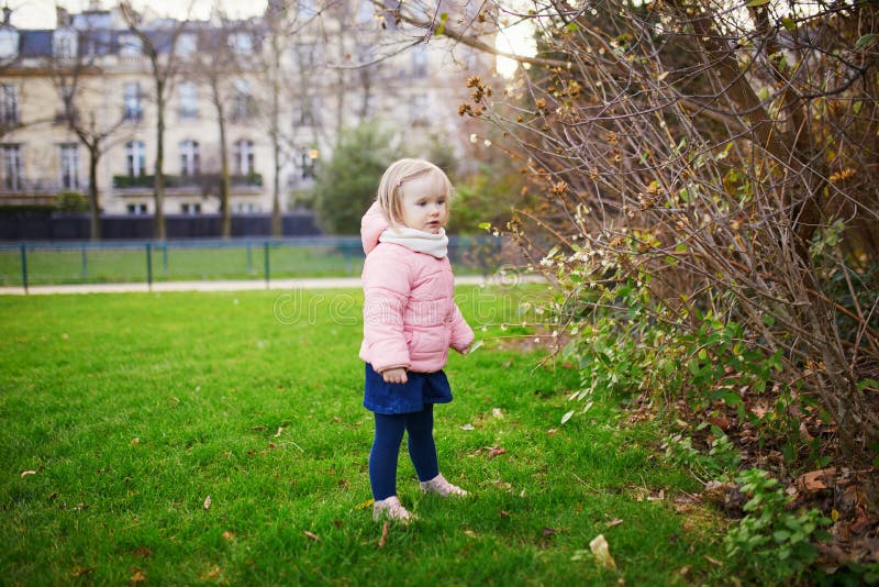 Adorable little toddler girl in Parisian park on a spring or fall day royalty free stock photos
