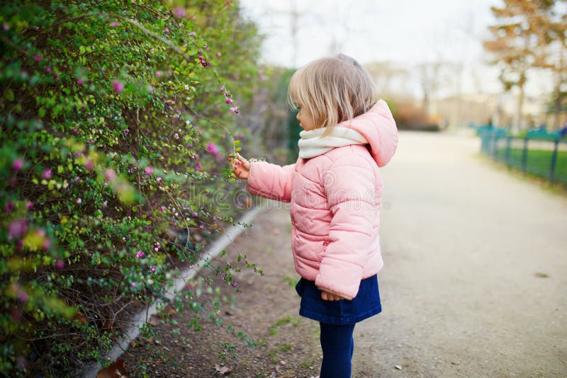 Adorable little toddler girl in Parisian park on a spring or fall day royalty free stock image
