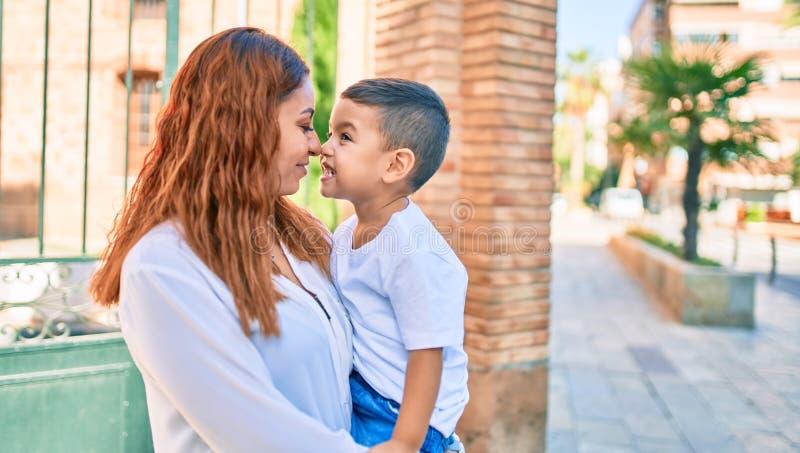 Adorable madre latina e hijo sonriendo alegre abrazo en la ciudad foto de archivo libre de regalías