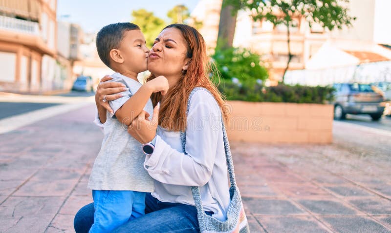 Adorable madre latina e hijo sonriendo feliz abrazando y besando en la ciudad fotografía de archivo libre de regalías