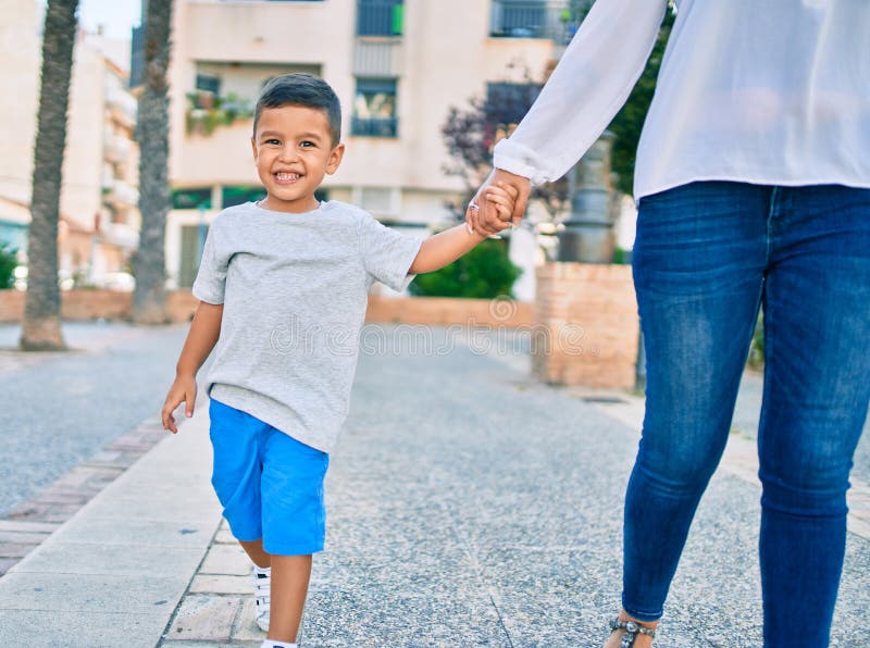 Adorable madre latina y su hijo caminando por la ciudad imágenes de archivo libres de regalías