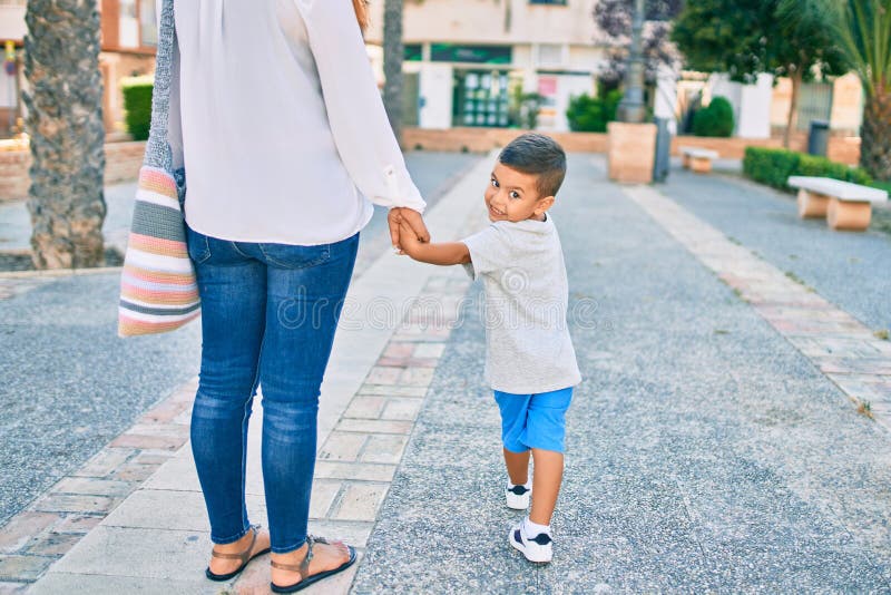 Adorable madre latina y su hijo caminando por la ciudad fotografía de archivo