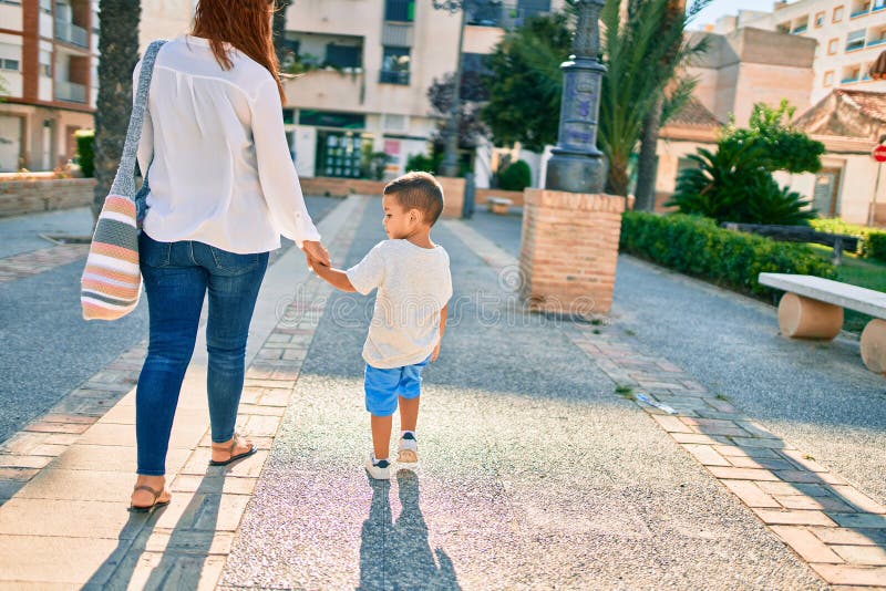 Adorable madre latina y su hijo caminando por la ciudad imagenes de archivo