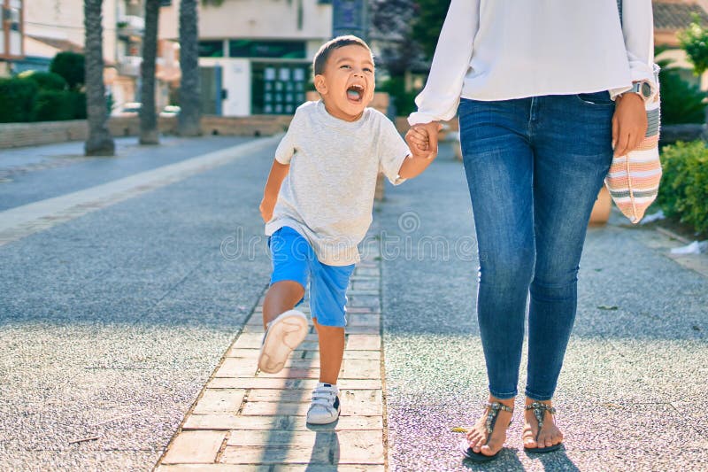 Adorable madre latina y su hijo caminando por la ciudad imagenes de archivo