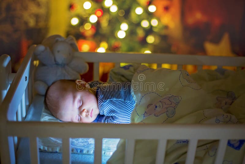 Adorable Newborn Baby Boy Sleeping In Crib At Night Stock Photo