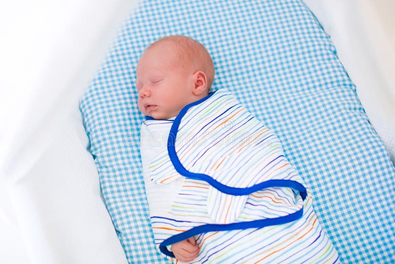 Adorable newborn baby sleeping swaddled in white bed. royalty free stock photos Adorable newborn baby sleeping swaddled in white bed. royalty free stock photos