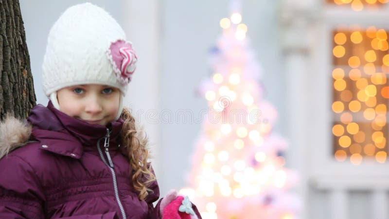 Adorable petite fille debout près d'un arbre clips vidéos