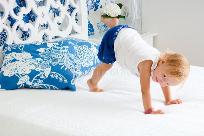 Adorable playful toddler girl in bedroom royalty free stock photography Adorable playful toddler girl in bedroom royalty free stock photography