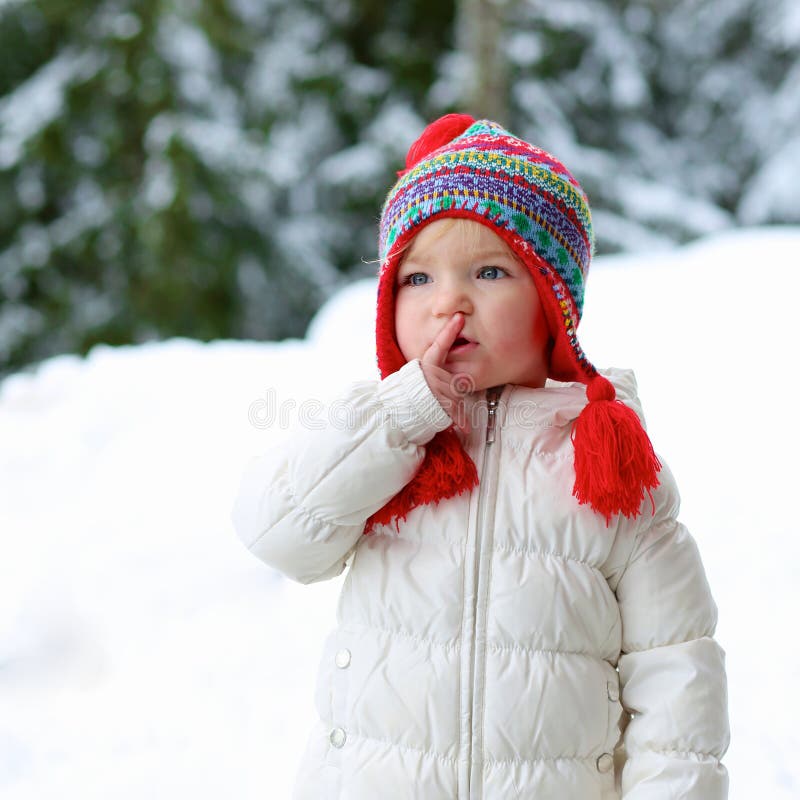 Adorable preschooler girl enjoys winter at ski resort