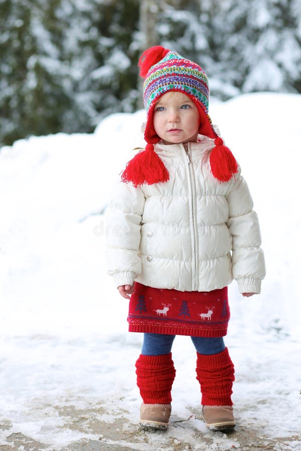 Adorable preschooler girl enjoys winter at ski resort