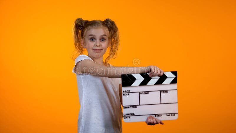 Adorable preteen girl clapping flapper pretending to be film producer, dream royalty free stock images Adorable preteen girl clapping flapper pretending to be film producer, dream royalty free stock images