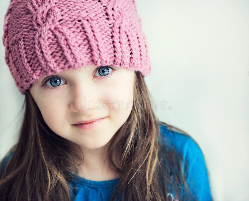 Adorable smiling child girl in pink knitted hat