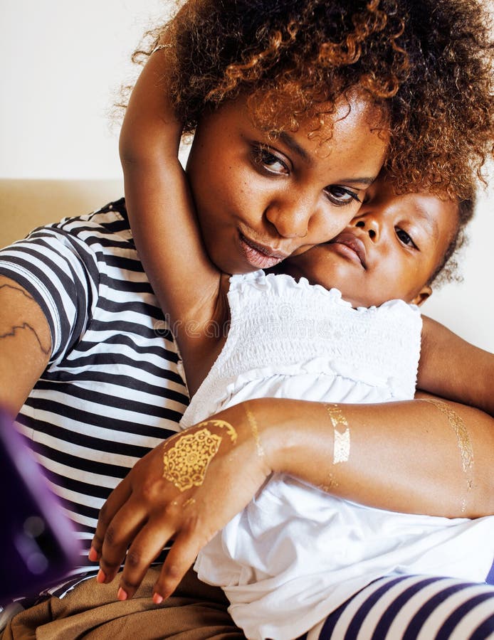 Adorable sweet young afro-american mother with cute little daughter, hanging at home, having fun playing smiling stock image Adorable sweet young afro-american mother with cute little daughter, hanging at home, having fun playing smiling stock image