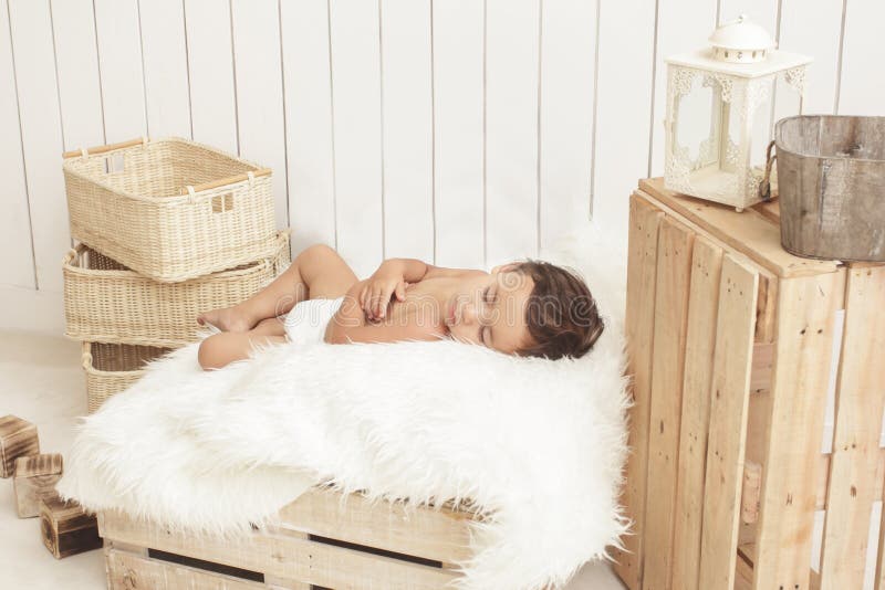 Adorable toddler sleeping on box with fur blanket royalty free stock photography Adorable toddler sleeping on box with fur blanket royalty free stock photography