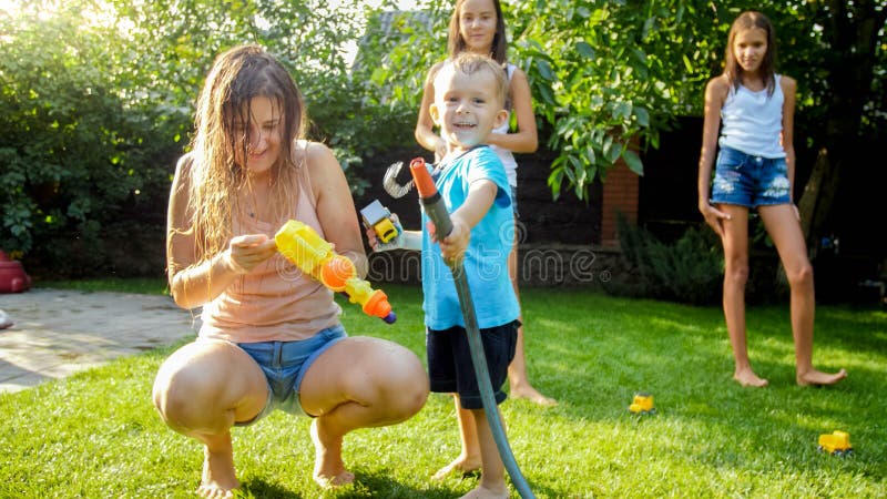 Adorable 3 years old toddler boy splashing water from plastic toy gun at house backyard. Children playing and having fun stock photography Adorable 3 years old toddler boy splashing water from plastic toy gun at house backyard. Children playing and having fun stock photography