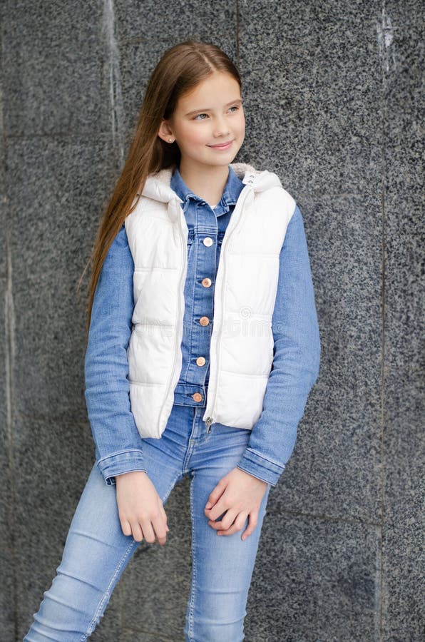 Adorable улыбаясь положение детей в парке на улице preteen маленькой девочки стоковые изображения