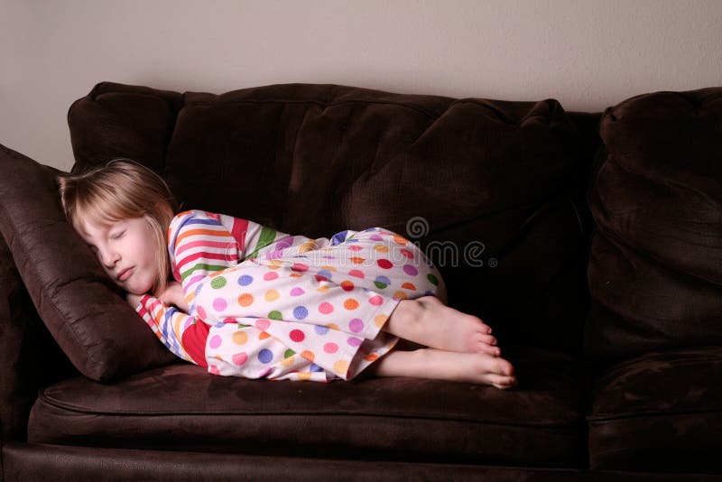 Adormecido acolhedor nos pijamas no sofá