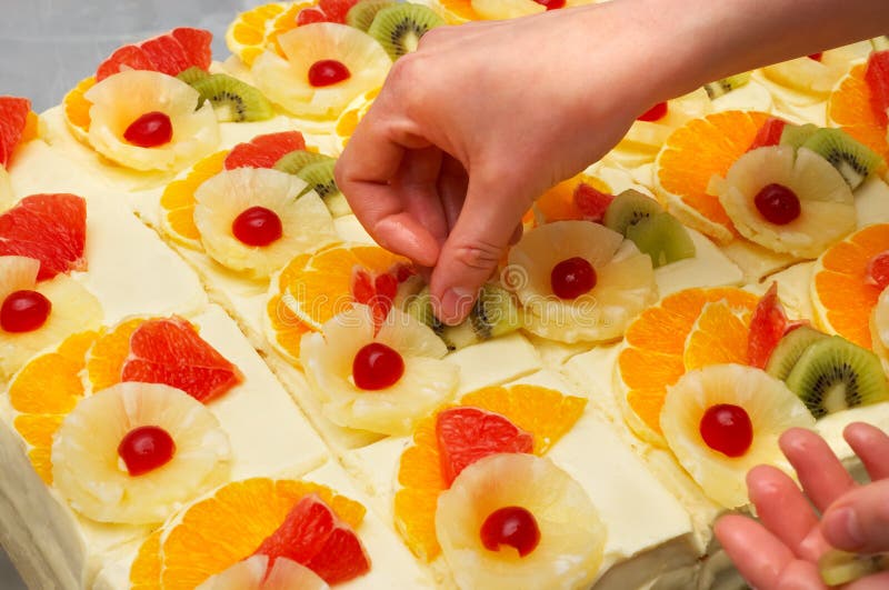 Decorating the custard filled cakes with fruits. Decorating the custard filled cakes with fruits