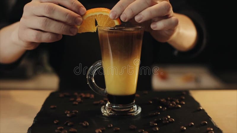 Adornamiento de una bebida del café helado con una rebanada anaranjada Un cierre para arriba almacen de metraje de vídeo