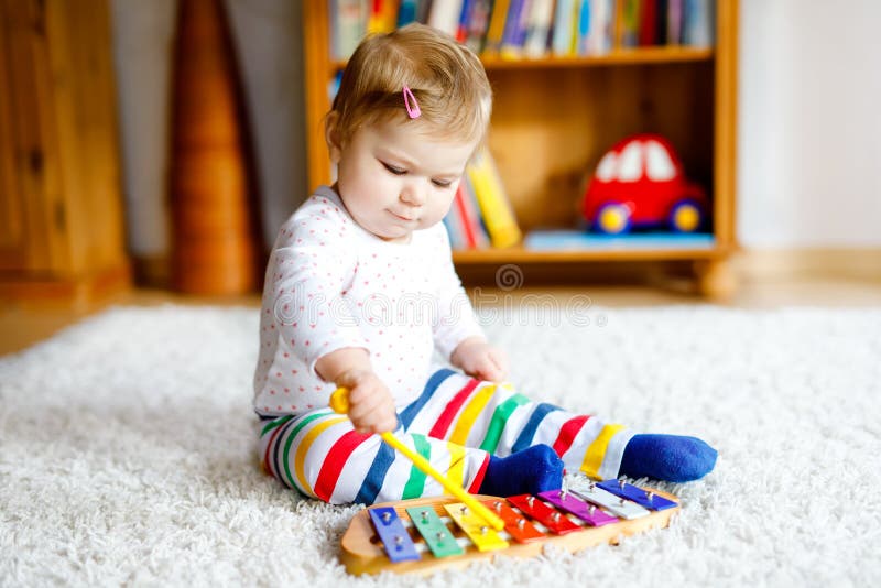 Adorável e linda menina brincando com brinquedos educacionais em casa ou no berçário Criança saudável e feliz tendo imagens de stock royalty free Adorável e linda menina brincando com brinquedos educacionais em casa ou no berçário Criança saudável e feliz tendo imagens de stock royalty free